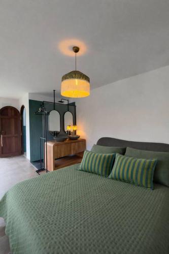 a bedroom with a green bed and a mirror at uBa Vineyard Stay con vistas al Miño Ribeira Sacra in Chantada