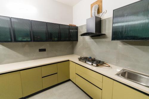 a kitchen with yellow cabinets and a sink at Casa Mog by Meraden in Vagator