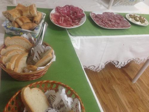 a table topped with plates of bread and meats at Hotel 2000 in Fabriano