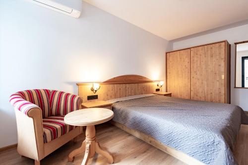 a bedroom with a bed and a chair and a table at Vitosha Park Apart in Sofia