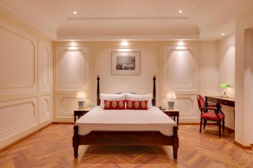 a bedroom with a bed and two chairs and a desk at Lemon Tree Hotel, Sri Ganganagar in Gangānagar