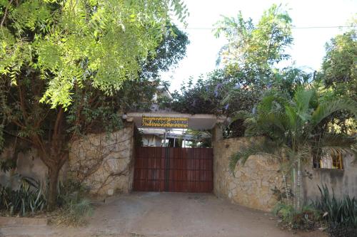 a gate in a stone wall with a red door at The Paradise In Kilimanjaro in Moshi