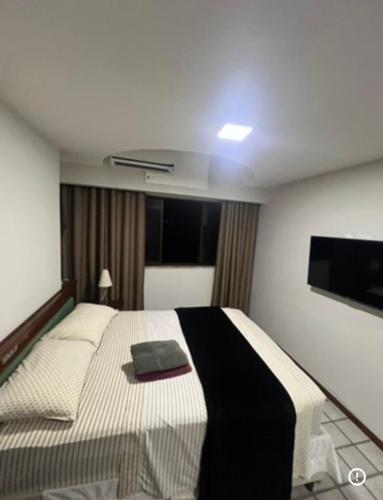 a bedroom with a bed and a flat screen tv at Praia da costa vista total in Vila Velha