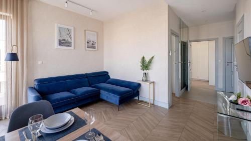 a living room with a blue couch and a table at Solmarina, Sun&Snow in Wiślinka
