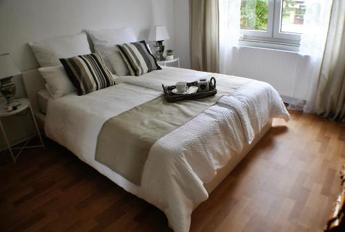 ein großes weißes Bett mit einem Tablett darüber in der Unterkunft Ferienwohnung Marina Kassel in Kassel