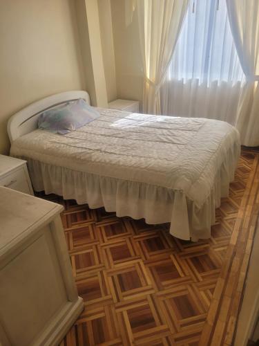 a bedroom with a bed and a wooden floor at La Casa del Turista Riobamba in Riobamba