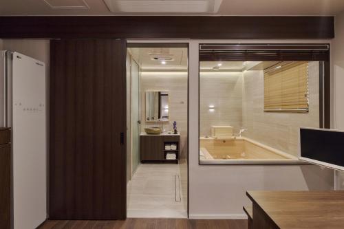 a bathroom with a sliding glass door leading to a tub at 웨일로 서울김포공항점 in Seoul
