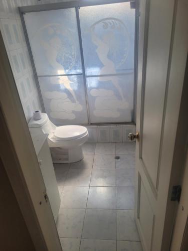 a bathroom with a toilet and a glass door at La Casa del Turista Riobamba in Riobamba