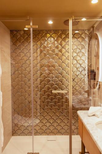 a shower with a glass door in a bathroom at Hôtel Le Monna Lisa by Inwood Hotels in Paris