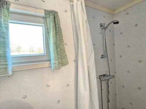 a shower with a shower curtain in a bathroom at Stuga 11 Dalskärs camping in Bergkvara