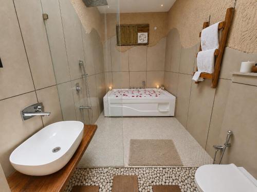 a bathroom with a sink and a bath tub at The Ark Resort in Bhopal