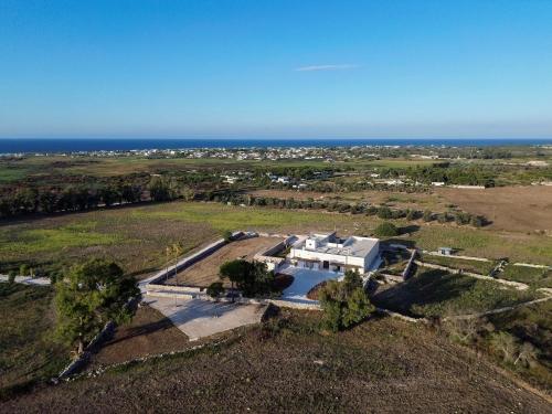 an aerial view of a white house in a field at Masseria LOGGIA PUCCI in Torre Chianca