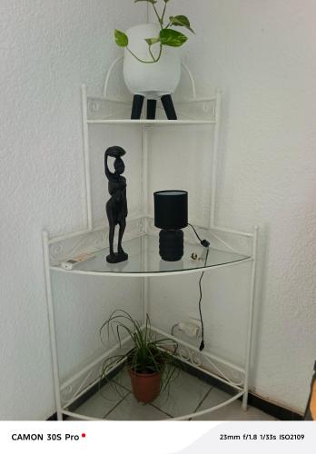 a shelf with a statue and a vase on it at Coin du paradis in Saly Portudal