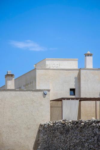 a building with a sign on the top of it at Masseria LOGGIA PUCCI in Torre Chianca