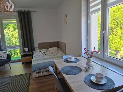 a bedroom with a bed and a table with two chairs at Apartament VERDE Malbork centrum in Malbork