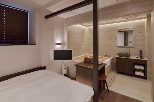 a bedroom with a bed and a bathroom with a sink at 웨일로 서울김포공항점 in Seoul