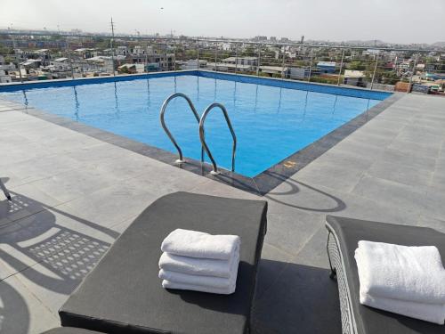a swimming pool with a table and towels on it at Regenta Place Jaipur , Jaipur in Jaipur