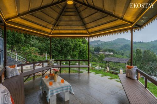 an outdoor patio with a table and chairs on a roof at EKOSTAY I Pearl House Villa I 360 Degrees Tea Estate in Ooty