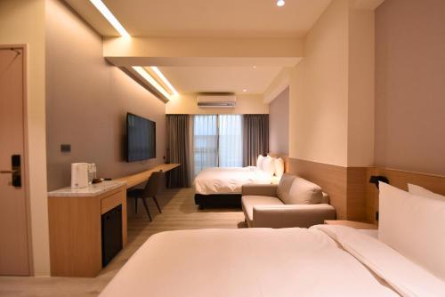 a hotel room with a bed and a television at Cheng House in Yuchi