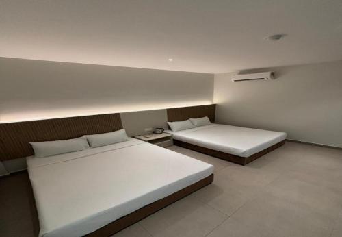 two beds in a small room with two beds sidx sidx sidx at Coastline Hotel 6 Avenue PortDickson in Port Dickson