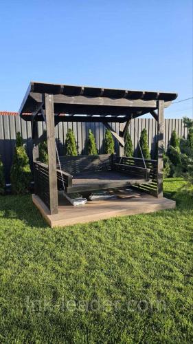 a wooden gazebo in the grass in a yard at Садиба in Vinnytsya