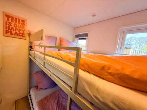 a bedroom with two bunk beds and a window at Tinyhouse mit Feuerstelle Capfun de Bongerd in Tuitjenhorn