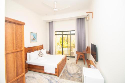a bedroom with a bed and a tv in a room at Mnazi Dream House in Kiwengwa