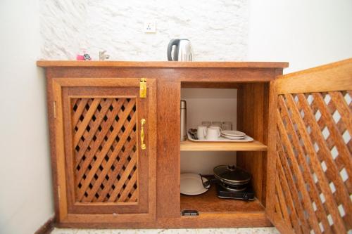 a wooden cabinet with a kitchen utensils in it at Mnazi Dream House in Kiwengwa