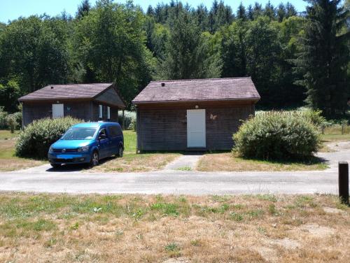 a blue van parked in front of a small building at Adapted chalet in La Chapelle-Taillefert