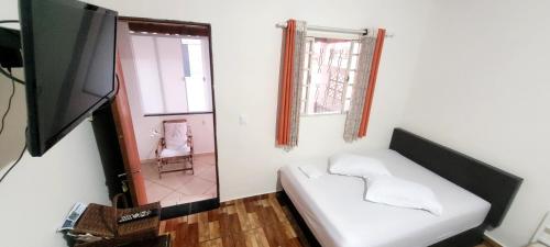 a living room with a white couch and a television at Casa Benta in Aparecida