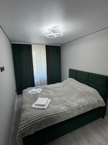 a bedroom with a bed with two towels on it at Premium 2-Room Rental in Bălţi