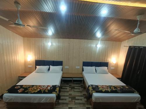 a room with two beds in a room with lights at Serene River Cottages Sadhupul in Jūnga