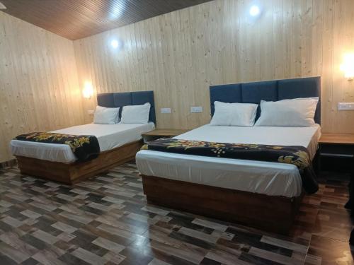 two beds in a room with two beds sidx sidx sidx sidx at Serene River Cottages Sadhupul in Jūnga