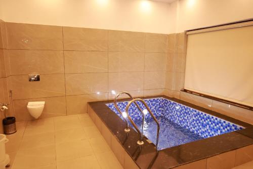 a bath tub in a bathroom with a toilet at The Corbett Manral Resort in Rāmnagar