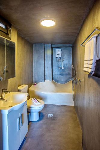 a bathroom with a tub and a toilet and a sink at Sunrise Suite in Kavála