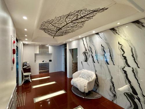 a living room with a white chair and a wall at Song-Jeong Bay Hotel in Busan
