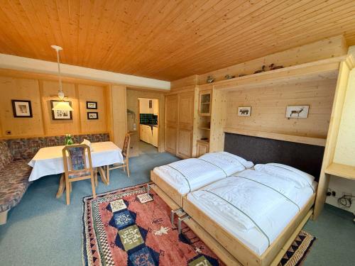 a bedroom with a bed and a table and a couch at Appartementhaus Birkenwald in Seefeld in Tirol