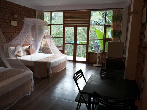 a bedroom with a bed and a desk and a table at Ayanura Ella in Ella