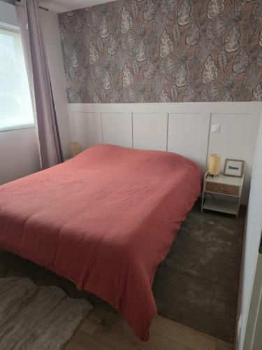 a bedroom with a red bed with a red blanket at L'Escale de la Râperie logement 4 in Tincourt-Boucly