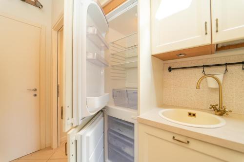 a bathroom with a sink and a refrigerator at The A-LINE Lake COMO view apt A with pool & garage in Tremezzo