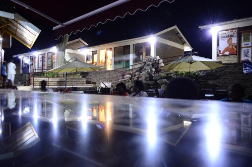 a group of people sitting at a restaurant at night at Koi Koi, Fort Portal in Fort Portal