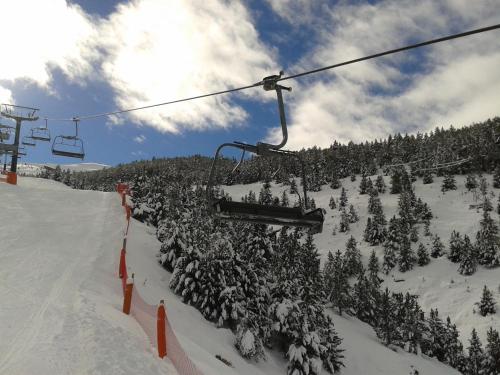 a ski lift with trees on a snow covered slope at Apartamentos Ball Benas Edificio Prados de Velarta in Cerler