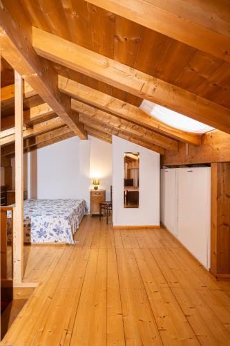 a bedroom with a bed and a wooden floor at Maso Simoni - Bazzanella in Piscine di Sover