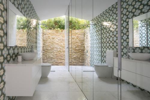 a bathroom with two sinks and two toilets at BelleVue Cala Vinyes in Cala Vinyes