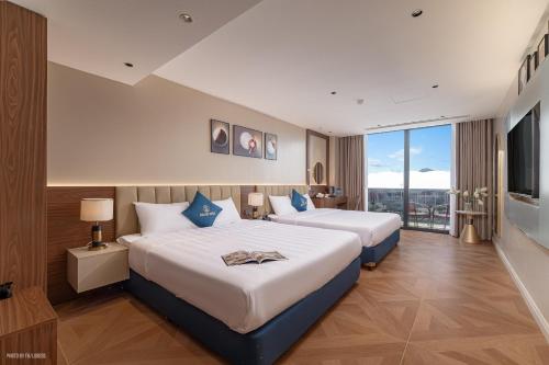 a hotel room with two beds and a large window at Solaya Hotel in Tài Xá