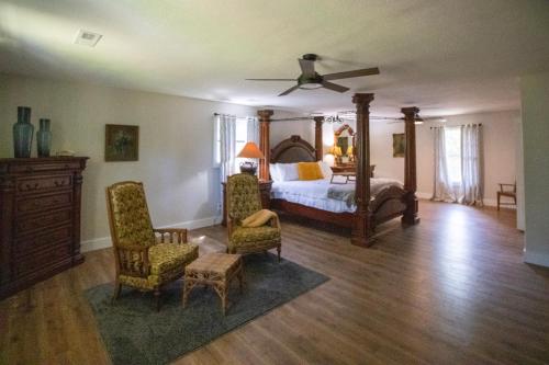 a bedroom with a bed and two chairs and a ceiling fan at Blindfrog in Scottsboro