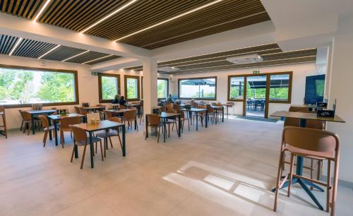 a restaurant with tables and chairs and windows at Gran Camping Zarautz in Zarautz