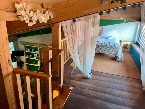 a room with a bed and stairs in a cabin at De Rietnymf in Munnekeburen