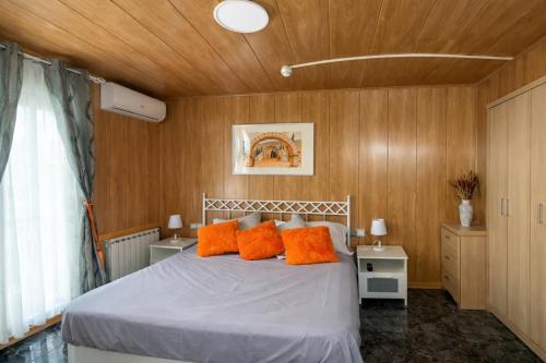 a bedroom with a bed with orange pillows at La Cassola del Priorat in Gratallops