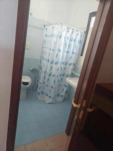 a bathroom with a toilet and a shower curtain at Gli Ulivi Residence in Leverano